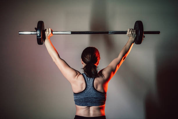 istock Woman workout in gym with barbell 1315391142