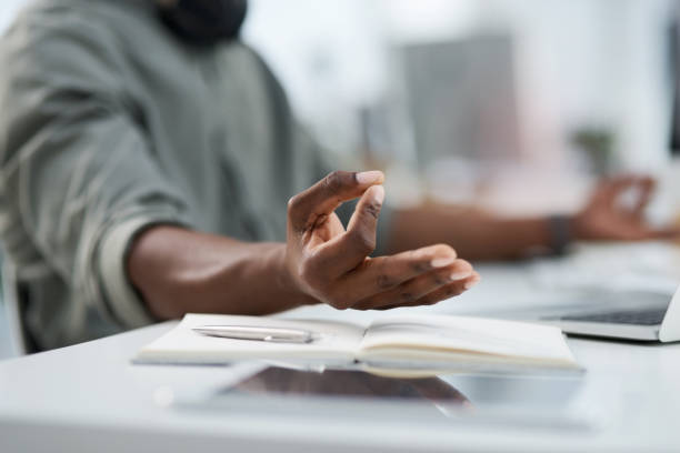 Cropped shot of a young man meditating at work