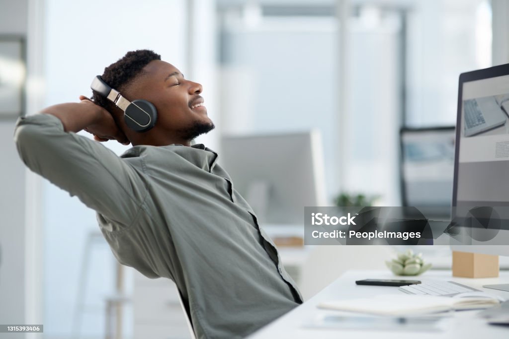Shot of a young man on a call at work in a office Time to take a break from the hustle Music Stock Photo