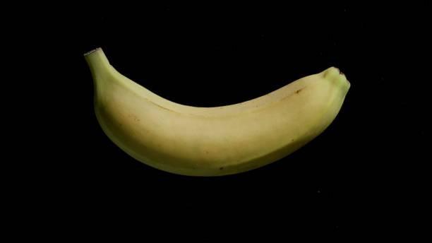 istock Single Whole Banana On A Black Background 1315393627