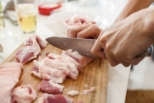 istock A man cook cuts pork meat with a knife. Cooking Concept 1315395292