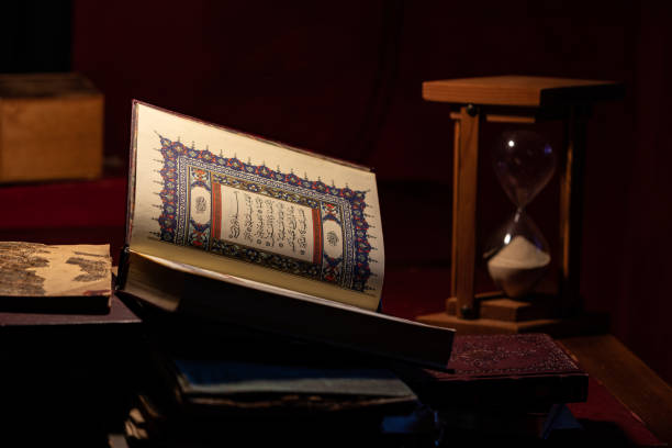 Photo Of Holy Koran And Hourglass On Table stock photo