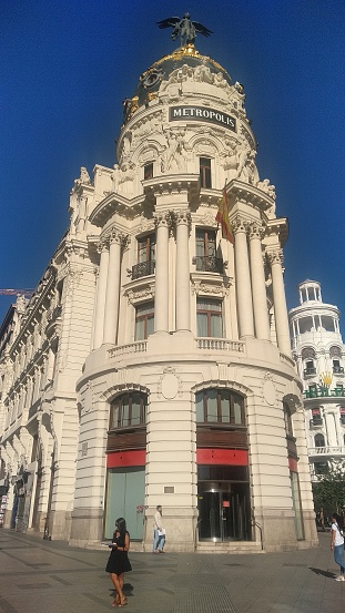 Image of a woman next to the Metropolis building in Madrid. The image was taken in the city of Madrid in August 2019.