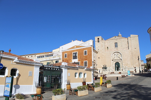Image taken in July 2020 during our trip to Menorca. The image shows a church and a market in the city of Mahon, in the east side of the island of Minorca. This area is the city center of the city and one of the sightseen