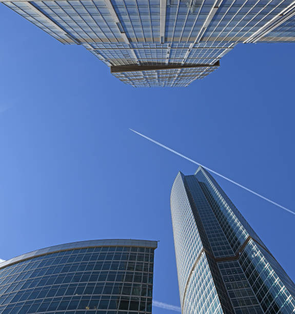 飛行機は春にモスクワ国際ビジネスセンターの超高層ビルの上に青空で飛んでいます - capital city trail ストックフォトと画像