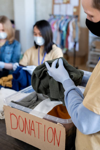 istock A person holding clothing item over donation container 1315406479