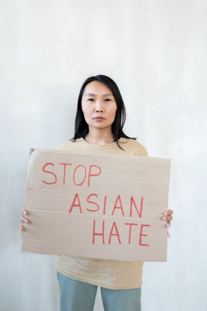 istock A woman holding a sign announcing protest against Asian hate 1315406492