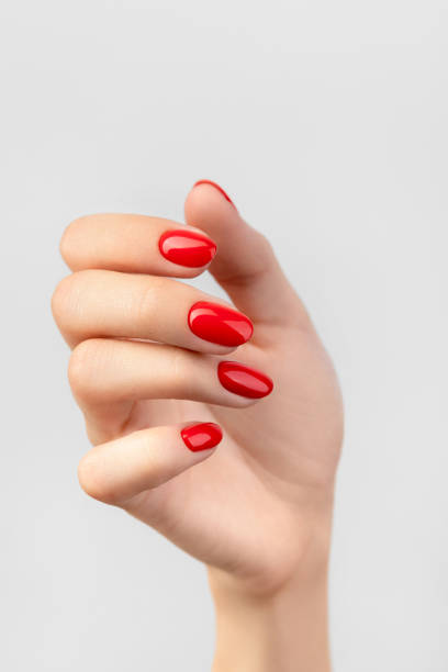 istock Beautiful womans hand with red manicure on gray background 1315406937