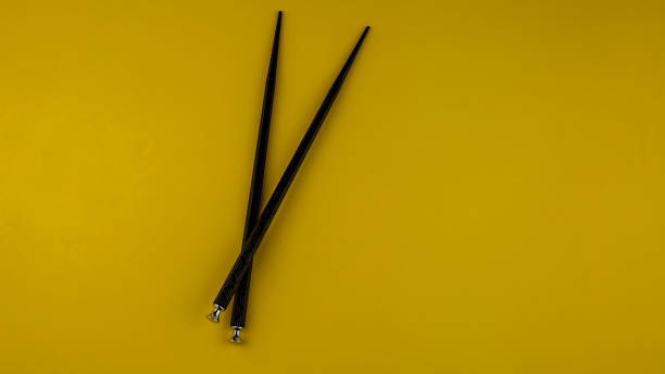 istock black sushi sticks on yellow background, isolated 1315408462