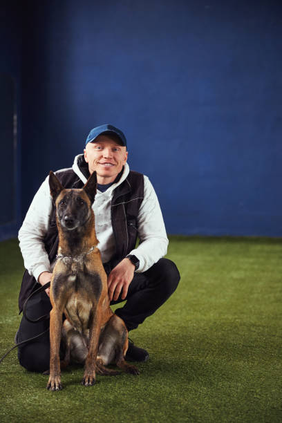 istock Belgian Malinois and a smiling instructor posing for the camera 1315408763