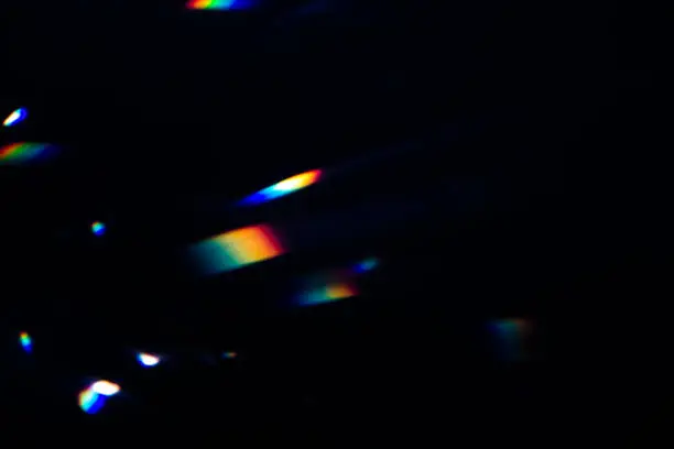 Photo of colorful warm rainbow crystal light leaks on black background