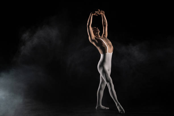danseur de ballet sur un fond noir - male body sport exercising photos et images de collection