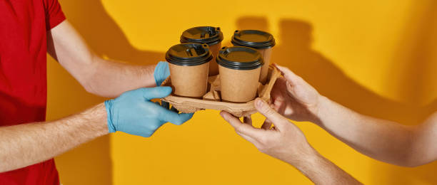 istock Courier hands in rubber gloves giving cups to customer 1315415008