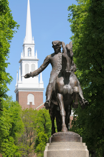 Paul Revere statue in Boston Freedom Trail, a national landmark and major tourist attraction. Old North Church steeple in the back.