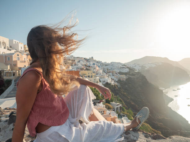 istock Woman contemplates Santorini from top, Greece 1315417209