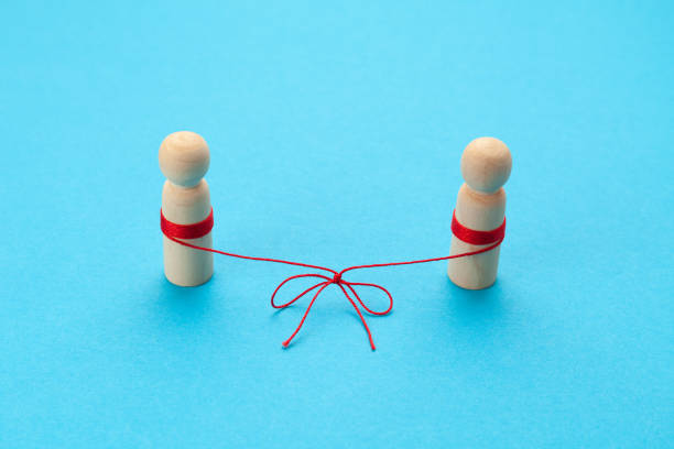 istock Reconciliation in relationships. Two figures of people are connected by a thread on a blue background. Married couple 1315420864