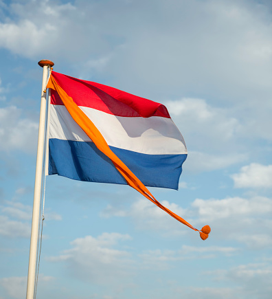 Dutch flag, red, white and blue with the orange pennant of the Royal Kingdom at the birthdayor kingsday of King Willem-Alexander