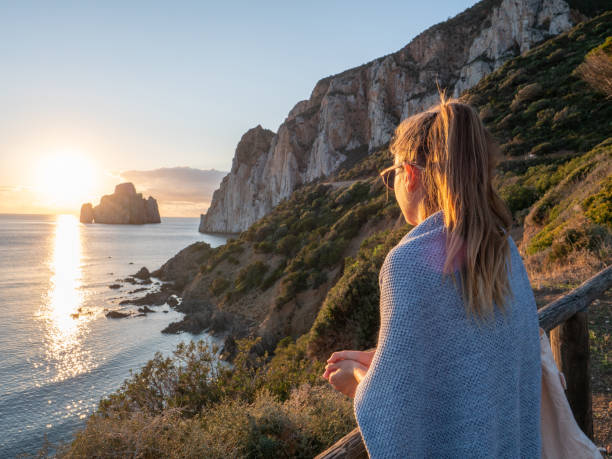 istock Woman contemplates beautiful sunset, Sardinia 1315424162