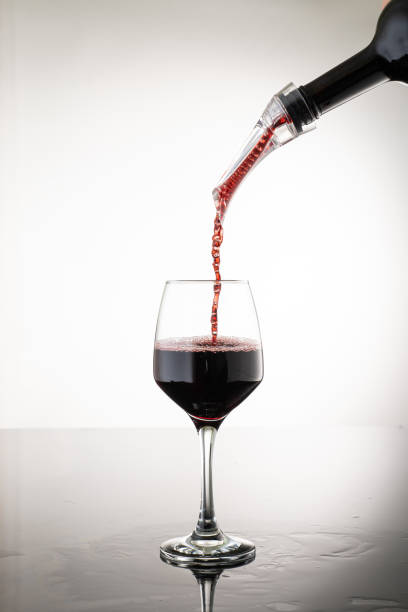 налить вино через аэратор, чтобы оксигенировать вино, поток вина с пузырьками - wine decanter red restaurant стоковые фото и изображения