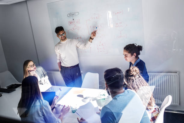 istock Team leader and his programmers in conference room.They discussing about development of new project. 1315432565