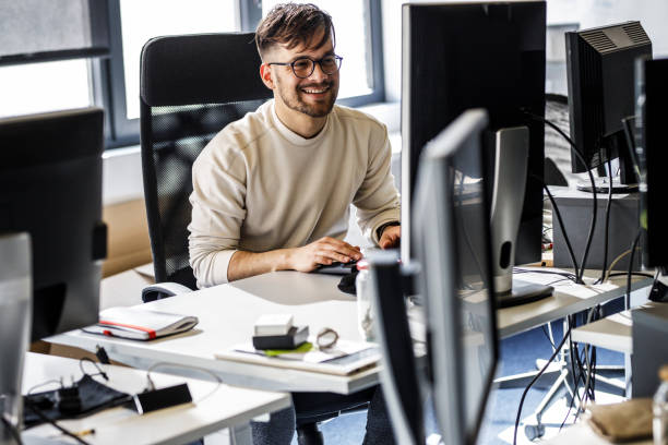 Programmer sitting at the desk in his office and trying to solve problem of new code.