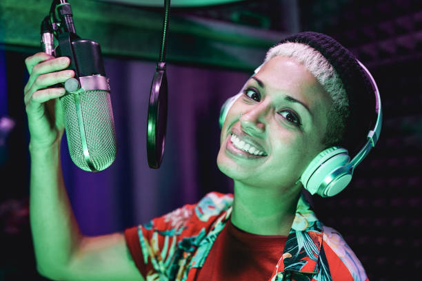 istock Female singer with microphone and headphone recording audio inside music studio 1315440938