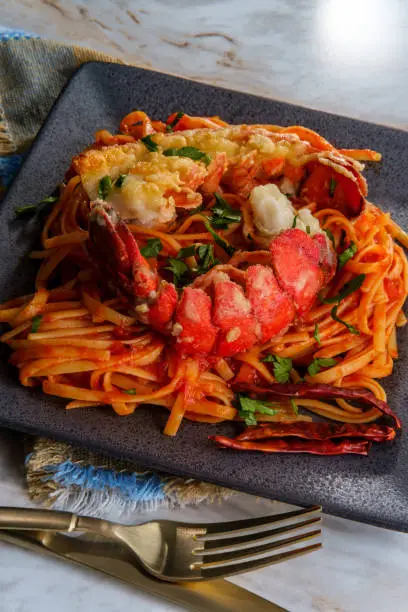 Pan fried sliced Italian lobster tail fra diavolo linguine