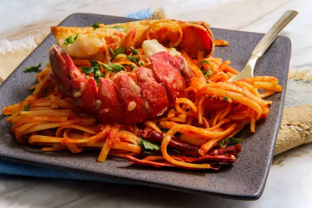 Pan fried sliced Italian lobster tail fra diavolo linguine