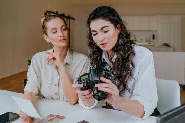 istock Two young women selecting photos on the camera indoor 1315443749