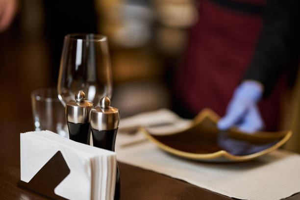 istock Rstaurant table with glasses and plates being set-up 1315444264