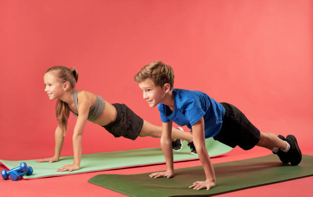 istock Adorable sporty kids doing plank against red background 1315444345