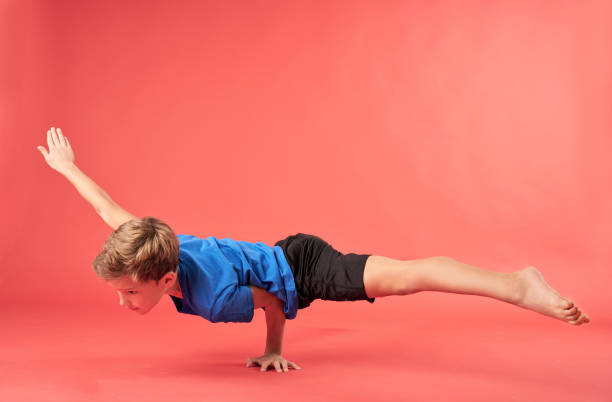 istock Adorable boy gymnast doing one arm handstand exercise 1315444357