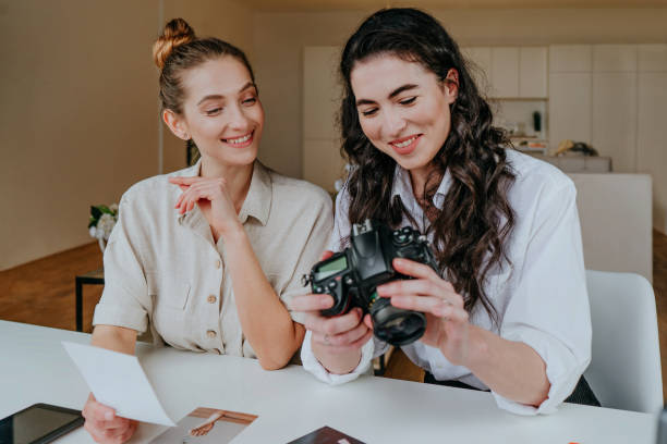 istock Two young women selecting photos on the camera indoor 1315444375