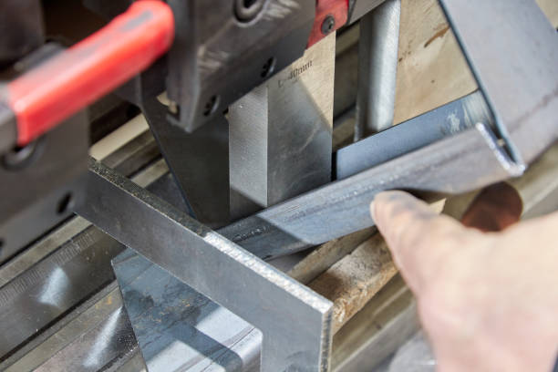 istock worker holding a metal part on sheet bending machine 1315444719