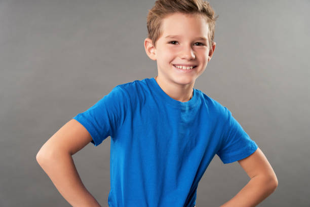 istock Cute cheerful boy standing against gray background 1315444958
