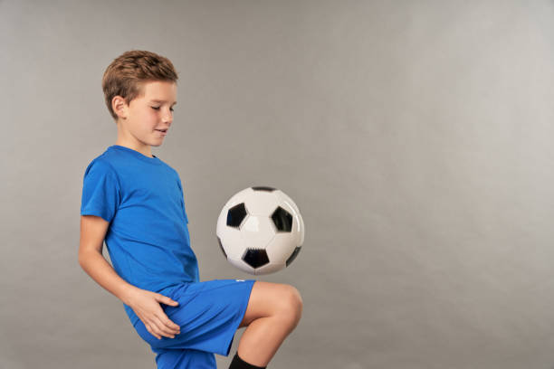 istock Little football player doing tricks with soccer ball 1315445019