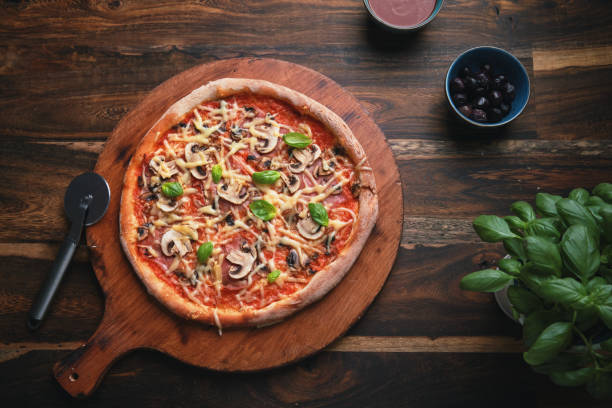 Freeze motion of falling various ingredients on pizza dough with sugo, top down view