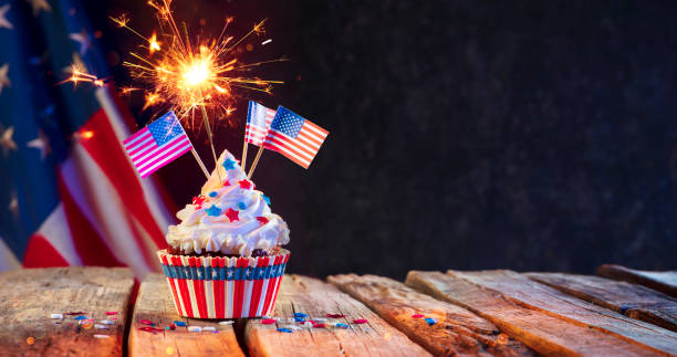 Cupcake Usa Celebration With American Flags And Sparkler Cupcake Usa Celebration With American Flags And Sparkler On Wooden Table fourth of july photos stock pictures, royalty-free photos & images