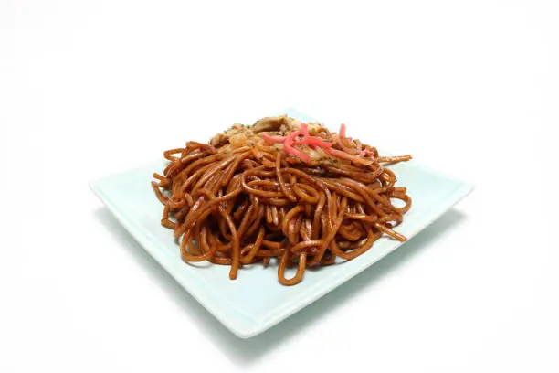Yakisoba which are stir fried noodles with pork,vegetables and a sweet and salty sauce on the plate.