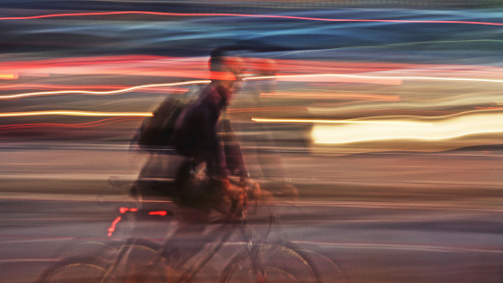 Man riding a bicycle in way of lights