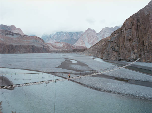 Woman walking on suspension bridge in Pakistan Young Caucasian woman walking on suspension bridge in Pakistan karakoram highway stock pictures, royalty-free photos & images