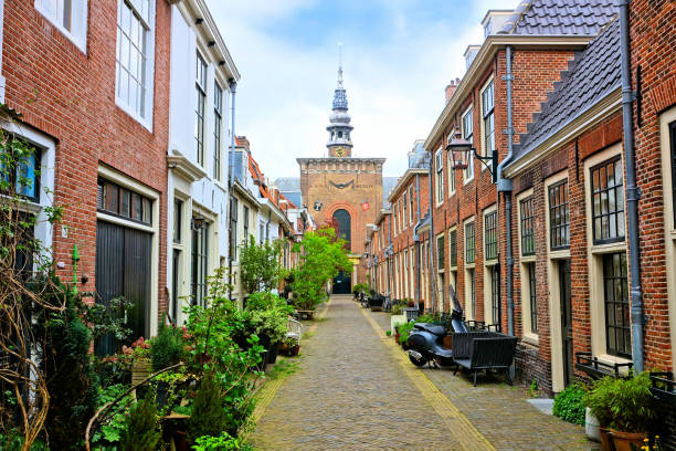 rue hollandaise feuillus avec la tour d’église, haarlem, pays-bas - banc déglise photos et images de collection