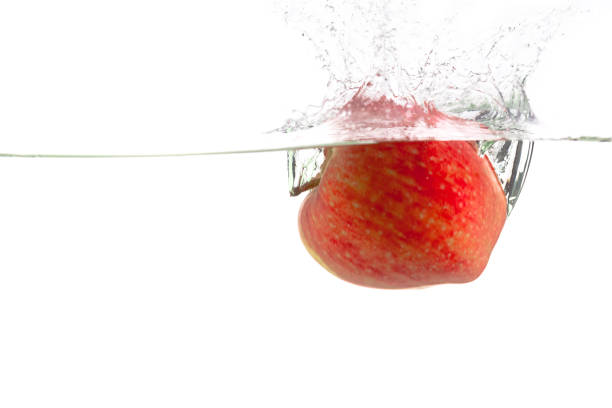 ripe red apple and clear water splash isolated on white