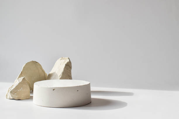 istock One white podium with a geometric concrete figure and stones. A scene with a cement display case. Minimalistic background. Presentation of cosmetics. Copy Space 1315482819