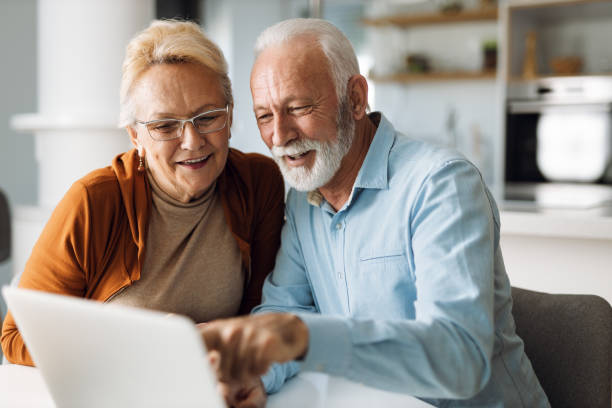 istock Cheerful  senior couple using laptop together at home 1315486080