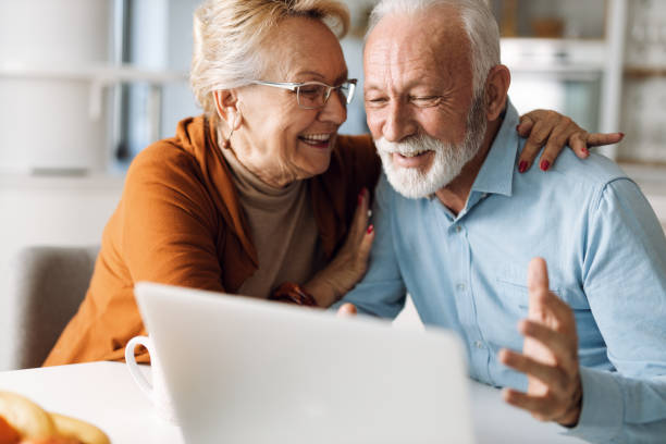 istock Cheerful  senior couple using laptop together at home 1315486222