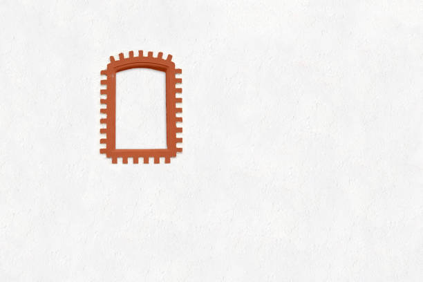 Earthy color brick decorative frame isolated on a pastel white wall background. Minimal mediterranean home facade concept with copy space.