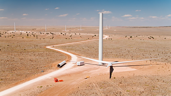 Several incomplete wind turbines rise from the New Mexico desert.