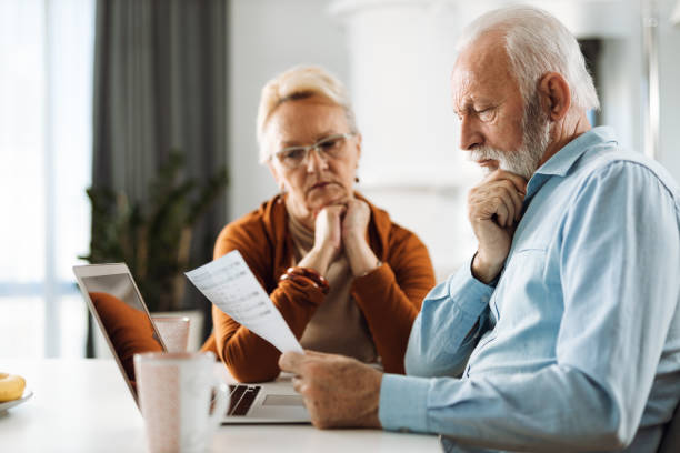 istock Old couple going through their finances together at home 1315489149