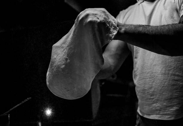 Chef tossing pizza dough stock photo Chef tossing pizza dough commercial kitchen photos stock pictures, royalty-free photos & images